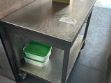 une table en métal sur laquelle est posé un récipient vert