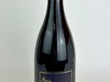 la bouteille de vin est posée sur une surface blanche