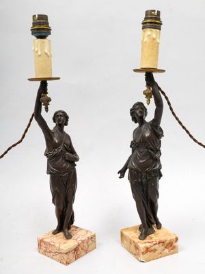 paire de figurines en bronze représentant une femme tenant un candélabre
