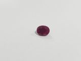 a single ruby stone on a white surface