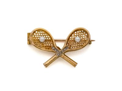 deux raquettes de tennis et une broche en perles sur fond blanc
