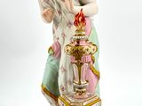 a figurine of a woman holding a vase on a table