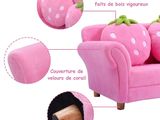 a picture of a pink couch with a strawberry on it