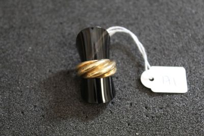 une bague posée par terre à côté d'une étiquette