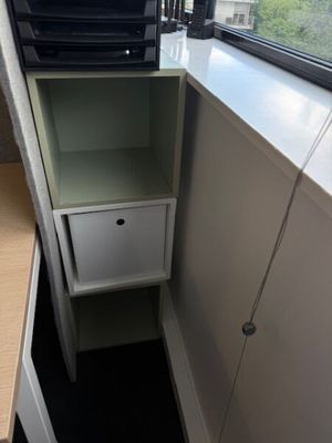 un micro-ondes posé sur un meuble près d'une fenêtre