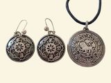 three pieces of silver jewelry sitting on top of a white surface