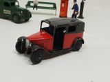 a red toy car and a green toy car on a white surface