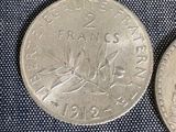 three different coins sitting on top of each other on a blue cloth