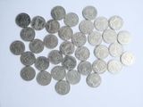a pile of silver coins on a white surface