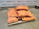 several bags of orange bags sitting on top of a wooden pallet