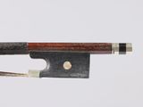 a close up of a bow on a white surface with a wooden handle