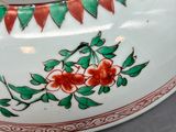 a white bowl with red and green designs on it