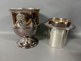 two silver vases sitting next to each other on a table