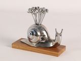a silver sculpture of a snail with a bunch of flowers on its head