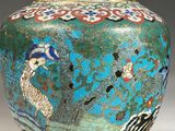 a blue vase with a bird on it on a stand