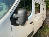 a van that is parked in the grass by the trees
