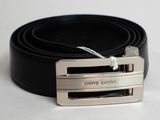 une ceinture noire ornée d'une boucle argentée sur un fond blanc
