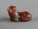 une petite figurine représentant un chien couché sur une table