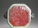 an image of a ring with a carved red stone in the center