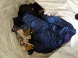 a blue sleeping bag on a bed with a pair of shoes