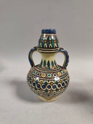 une paire de vases en céramique posés sur une surface blanche, sur fond blanc