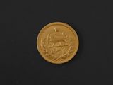 a close up of a gold coin on a black surface