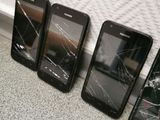 four cell phones are sitting next to each other on the floor