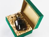 a bottle of liquor in a green box on a white surface