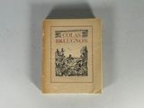 un vieux livre posé sur une table à côté d'un mur blanc