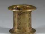 an old brass spool with a hole in the middle