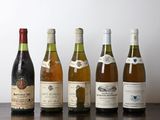 plusieurs bouteilles de vin sont alignées sur une table en bois