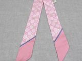 a close up of a pink and blue tie on a gray surface