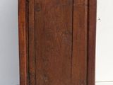 a small wooden cabinet with a door on top of it