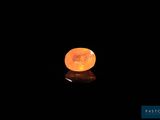 un gros plan d'une pierre orange sur une surface noire