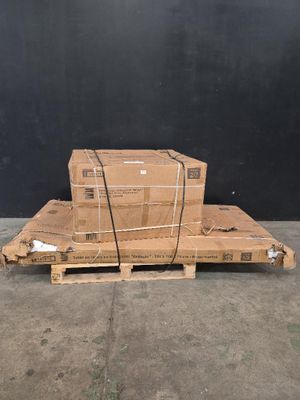 Deux cartons sont empilés sur une palette devant un mur noir
