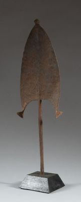 une photo d'une sculpture en bois représentant une feuille, posée sur un socle en métal