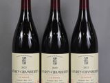three bottles of red wine are lined up on a table