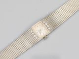 a close up of a wrist watch on a silver mesh bracelet