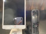 two cell phones sitting on a table next to a cell phone