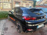 a black bmw suv parked on the side of the street
