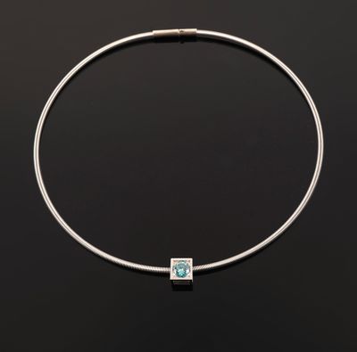 a silver necklace with a blue topaz stone on a black background