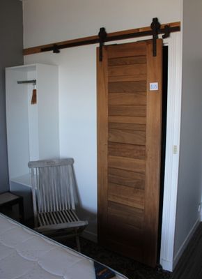 un lit et une chaise dans une pièce dotée d'une porte coulissante
