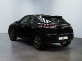 the rear end of a black suv parked in a white room