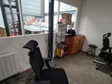 a black office chair sitting in a room with a large window