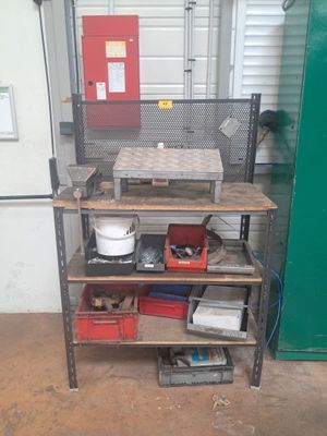 un établi dans un garage, sur lequel sont posés de nombreux outils