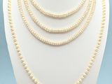 a white necklace with pearls on a mannequin