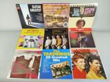 several albums of various music are on display on a table