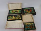 quatre petites boîtes ornées de peintures, posées sur une table