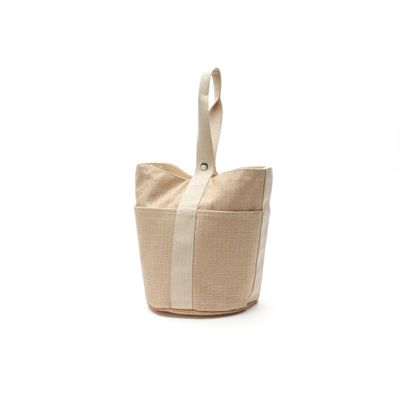 un sac fourre-tout beige et blanc posé sur une surface blanche