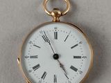 une montre de poche en or avec des chiffres romains sur le cadran